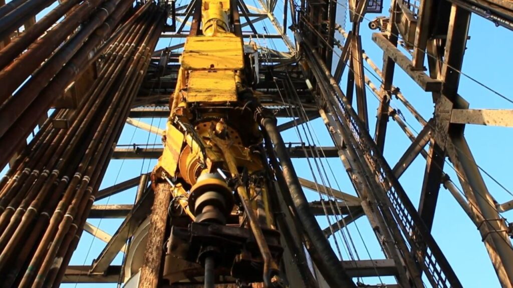 Close-up view of a top drive system installed on a drilling rig, featuring modern equipment designed for enhanced drilling performance and efficiency.